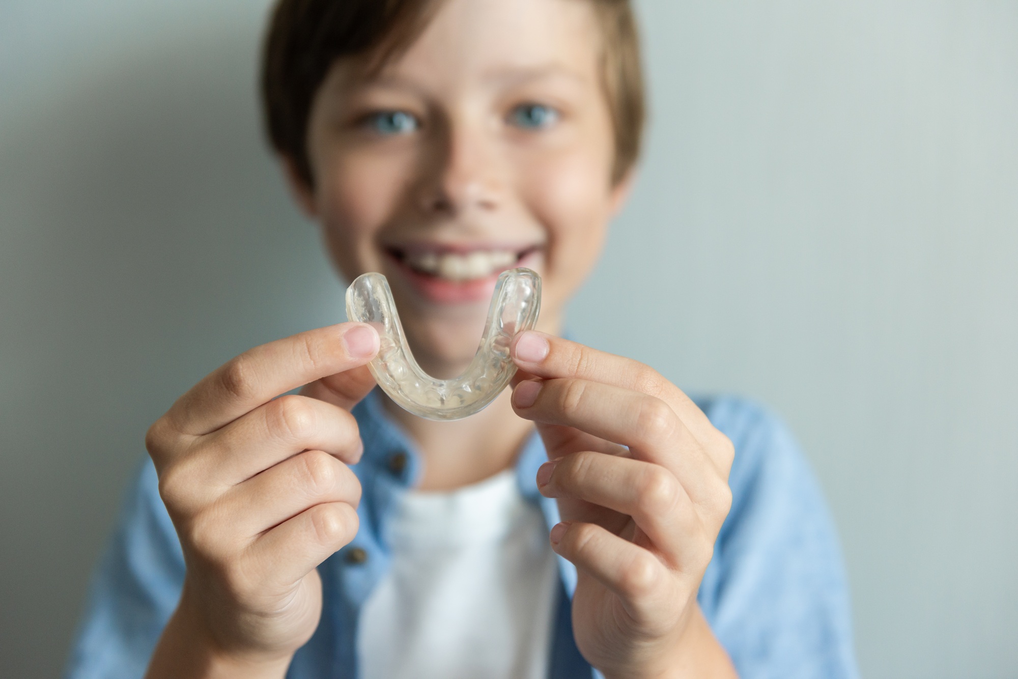 Smiling boy with braces and Invisalign and mouthguard concept. Orthodontic oral care for teenagers
